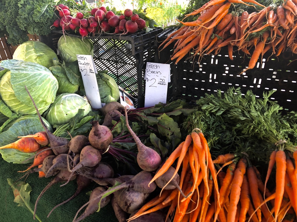 A variety of vegetables in a booth at a farmers' market