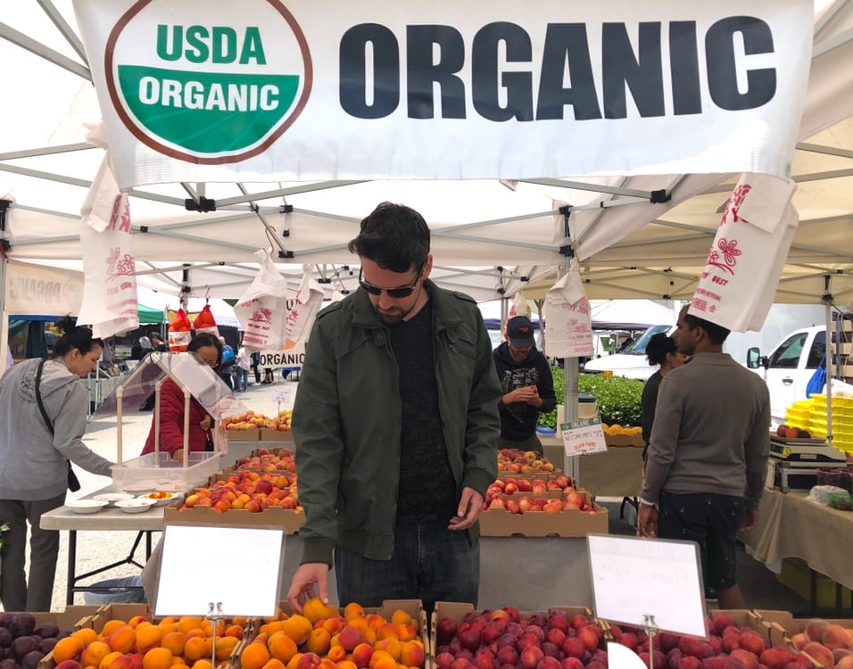 Man picks out organic produce at farmers' market