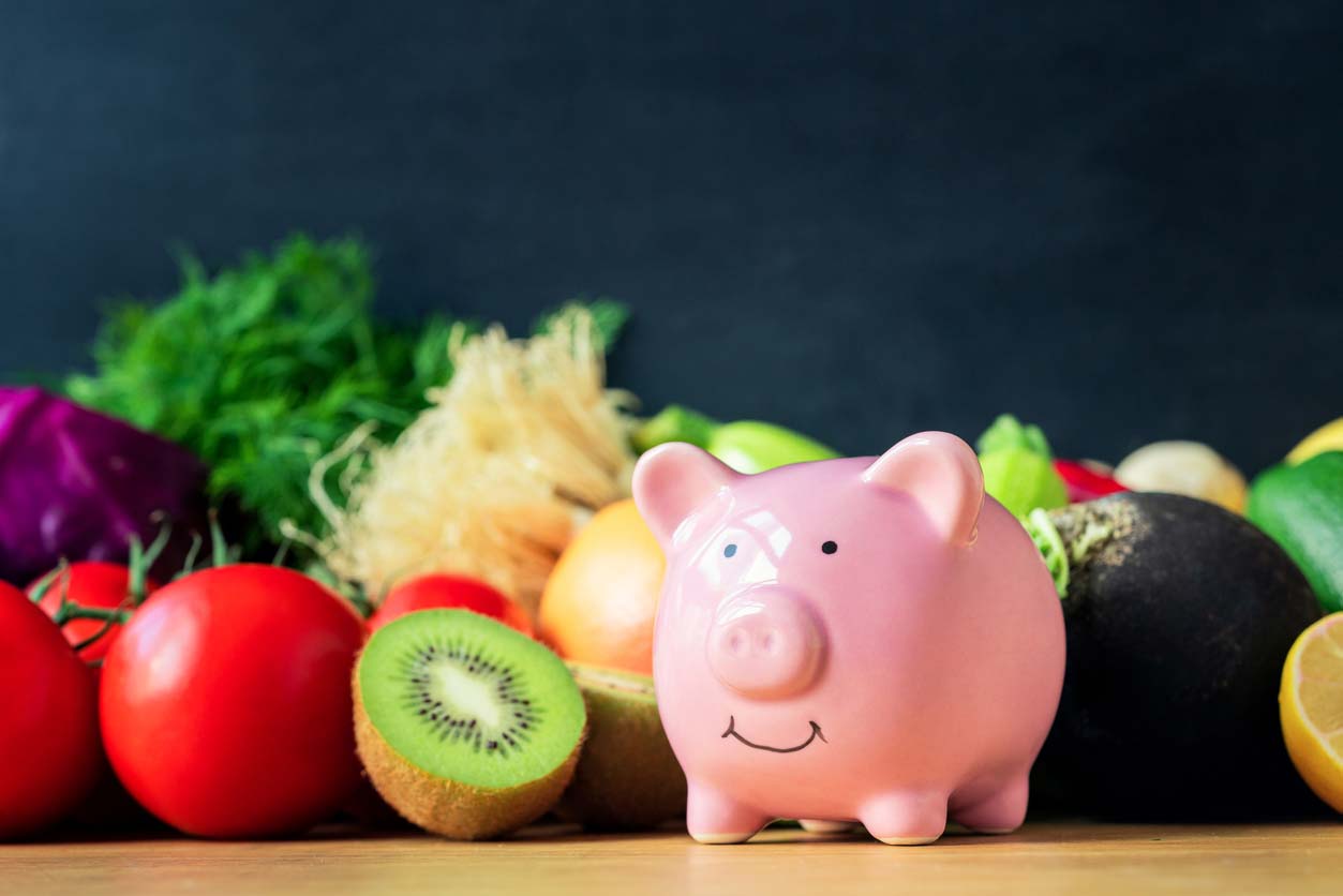 Fruits and veggies with a piggy bank