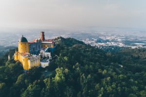 Aerial panorama of colorful Pena castle in the foggy morning. Travel in Portugal.