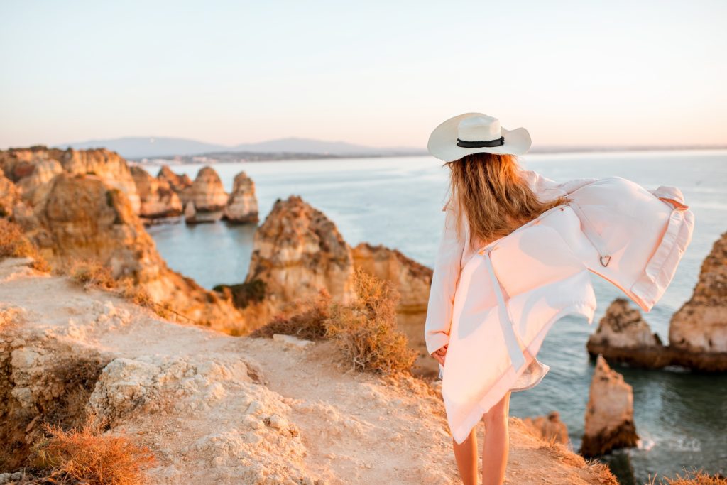 Woman traveling on the rocky coastline in Lagos, Portugal